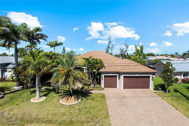 3824 SW 11th Pl, Cape Coral, FL 33914 - view of front of house with a garage, a tiled roof, concrete driveway, and a front yard