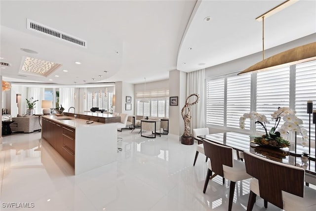 kitchen featuring a sink, open floor plan, visible vents, modern cabinets, and light tile patterned flooring
