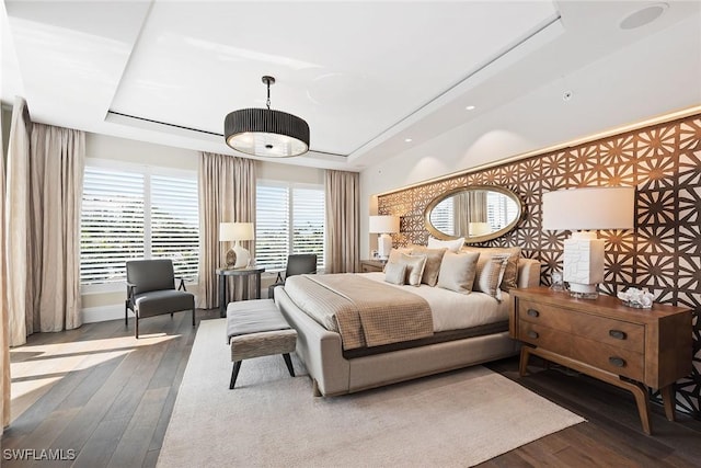 bedroom featuring a raised ceiling and wood finished floors