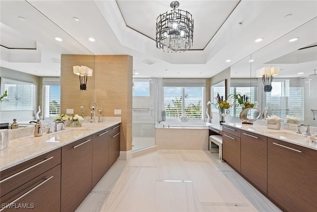 bathroom with a sink, a stall shower, a wealth of natural light, a raised ceiling, and a bath