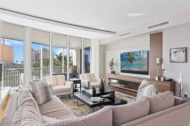 living room with expansive windows, visible vents, and wood finished floors