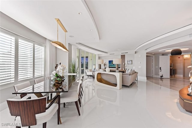 dining area with arched walkways, tile patterned flooring, and baseboards
