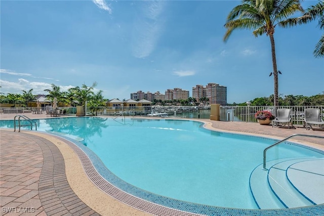 pool with a patio area and fence