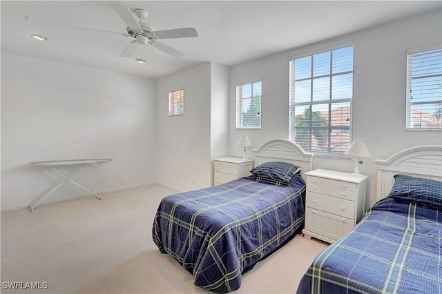 bedroom featuring light carpet and a ceiling fan