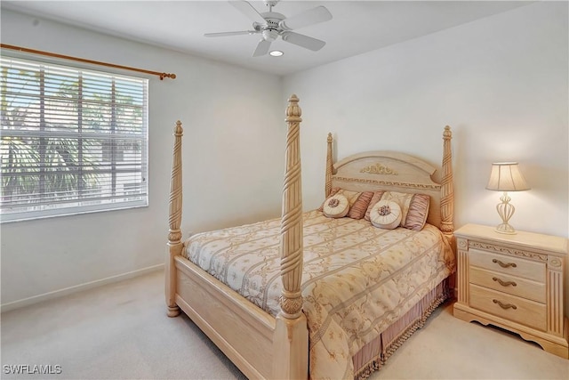 bedroom with baseboards, multiple windows, ceiling fan, and light colored carpet