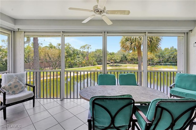 sunroom featuring a wealth of natural light, a water view, and a ceiling fan