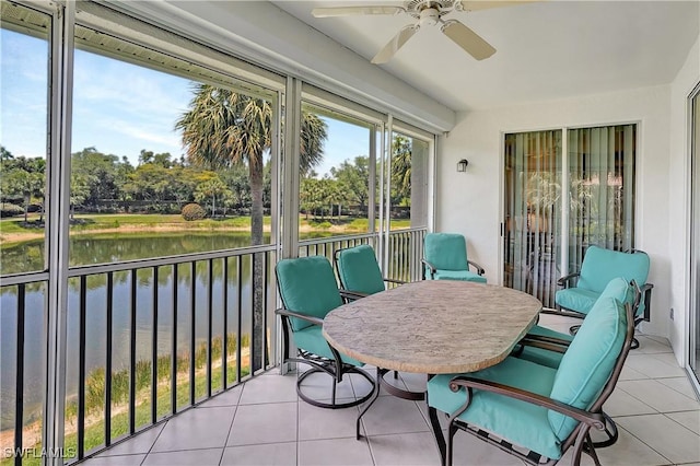sunroom / solarium with a water view and a ceiling fan
