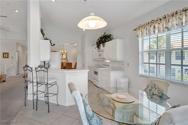 dining area featuring light tile patterned floors, lofted ceiling, an inviting chandelier, and plenty of natural light