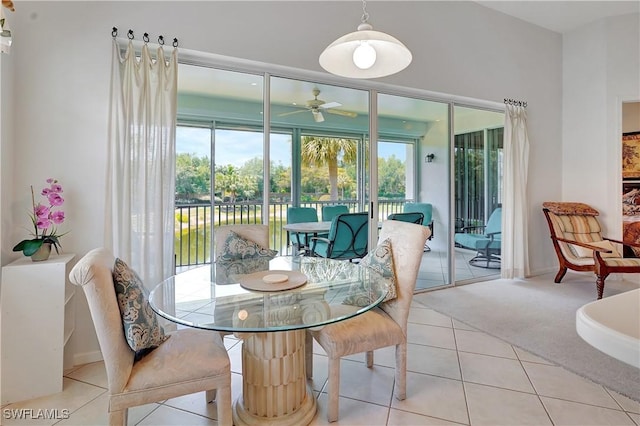 carpeted dining space featuring tile patterned floors and ceiling fan