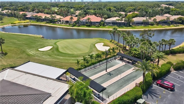 drone / aerial view with view of golf course, a water view, and a residential view