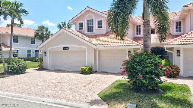 view of front facade with driveway, stucco siding, and a tile roof