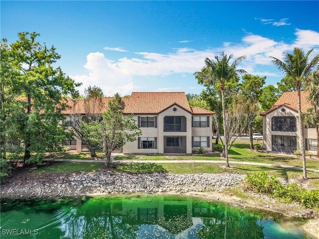2178 Arbour Walk Cir Unit 2322, Naples, FL 34109 - back of property featuring stucco siding and a yard