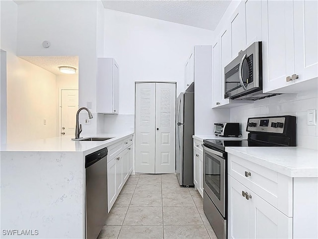 2178 Arbour Walk Cir Unit 2322, Naples, FL 34109 - kitchen featuring appliances with stainless steel finishes, a sink, a peninsula, light countertops, and a textured ceiling