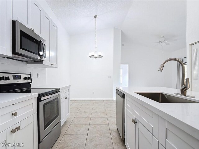 2178 Arbour Walk Cir Unit 2322, Naples, FL 34109 - kitchen featuring stainless steel appliances, a sink, vaulted ceiling, a chandelier, and light countertops
