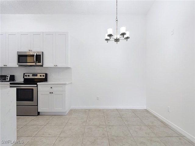 2178 Arbour Walk Cir Unit 2322, Naples, FL 34109 - kitchen featuring appliances with stainless steel finishes, a chandelier, light countertops, and white cabinets