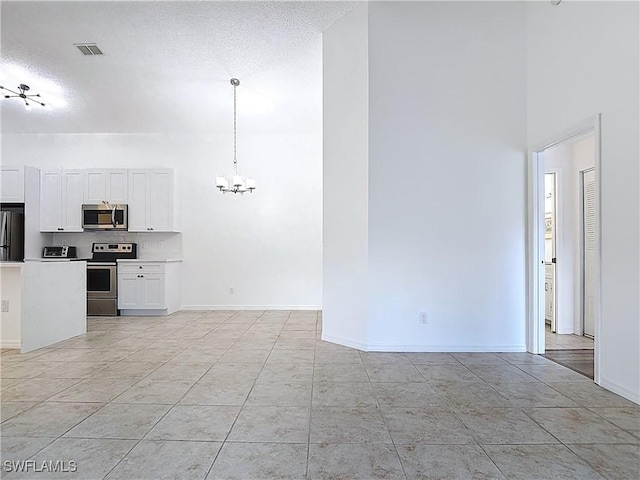 2178 Arbour Walk Cir Unit 2322, Naples, FL 34109 - unfurnished living room featuring a chandelier, a high ceiling, a textured ceiling, light tile patterned floors, and baseboards
