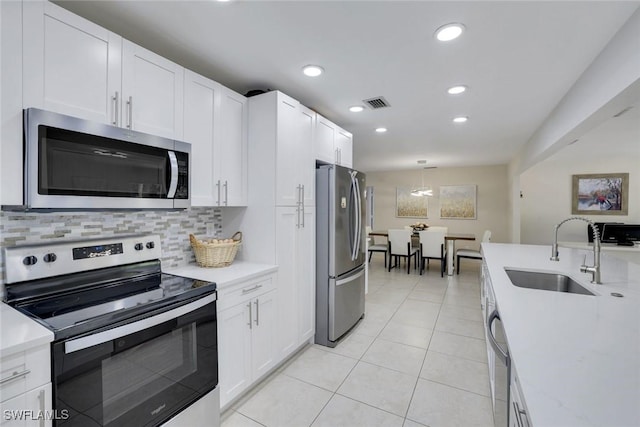 2855 66th St SW, Naples, FL 34105 - kitchen with stainless steel appliances, a sink, light countertops, decorative backsplash, and recessed lighting