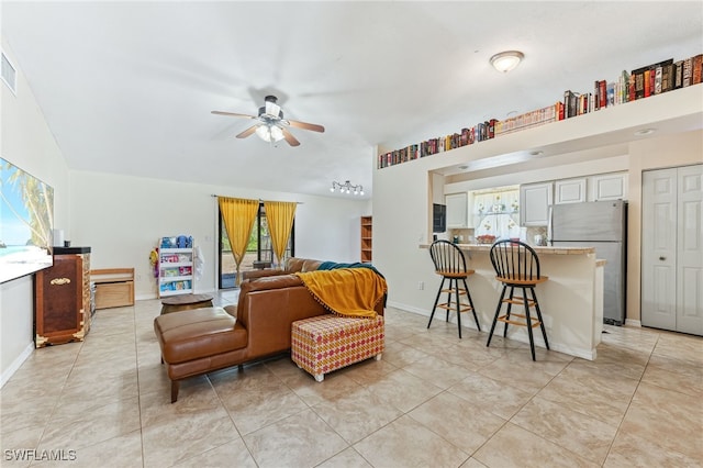 living area featuring a healthy amount of sunlight, ceiling fan, and light tile patterned flooring