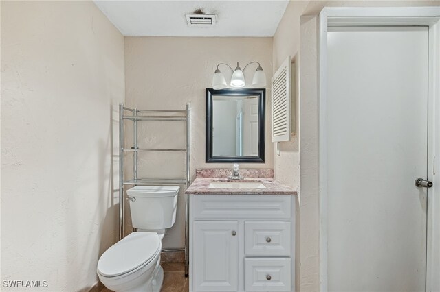 bathroom with visible vents, toilet, and vanity