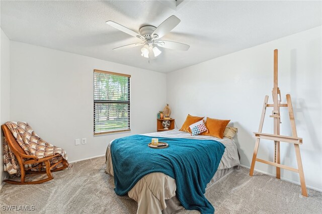 carpeted bedroom featuring baseboards, a ceiling fan, and a textured ceiling
