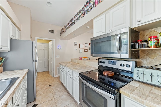 kitchen featuring backsplash, white cabinets, and appliances with stainless steel finishes