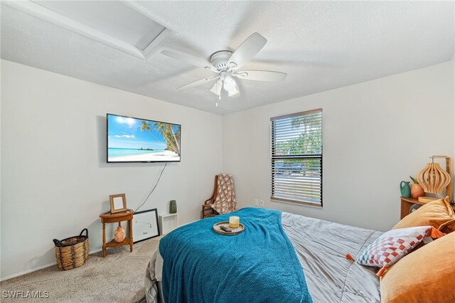 bedroom featuring a ceiling fan, carpet, and attic access