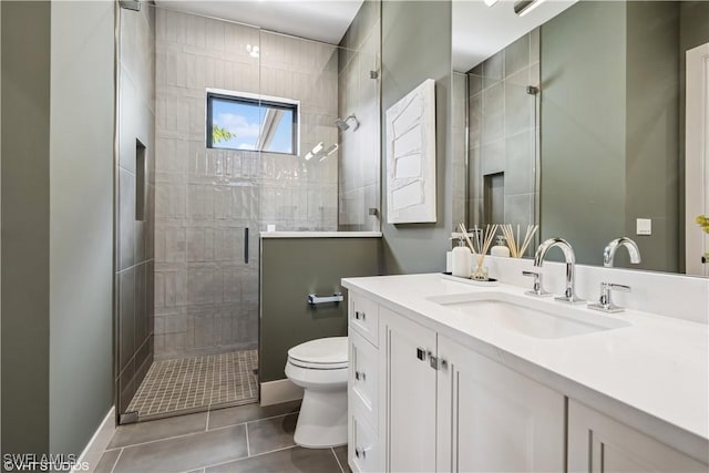full bathroom with tile patterned flooring, a stall shower, vanity, baseboards, and toilet