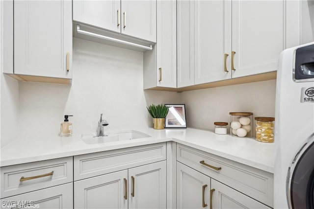 clothes washing area with a sink and cabinet space