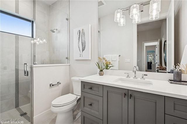 bathroom featuring vanity, a shower stall, toilet, and visible vents
