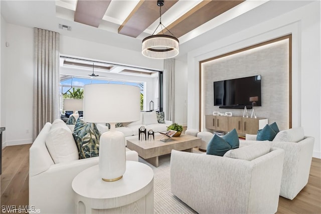 living room featuring baseboards, a ceiling fan, wood finished floors, and visible vents