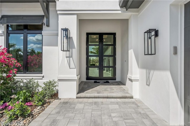 doorway to property featuring french doors and stucco siding