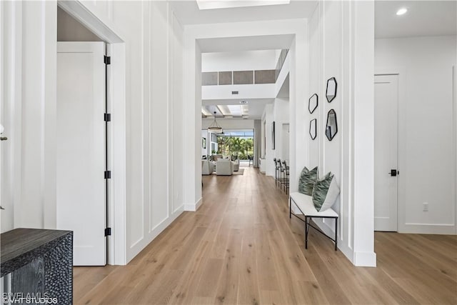 hallway featuring light wood-style floors and baseboards
