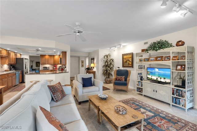 living area featuring track lighting, a ceiling fan, and visible vents