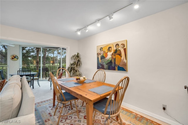 dining area with track lighting and baseboards