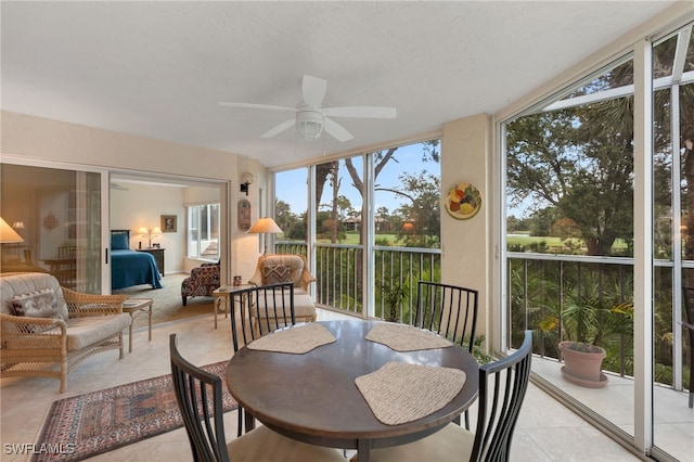 sunroom / solarium with tile patterned floors and ceiling fan