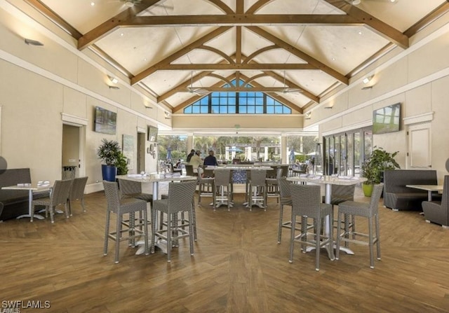 dining area with high vaulted ceiling and beamed ceiling