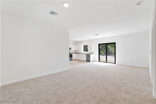 unfurnished living room with light carpet, baseboards, visible vents, and recessed lighting