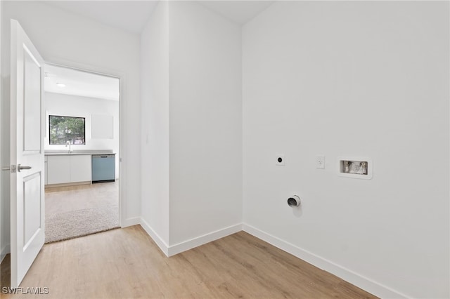 clothes washing area featuring light wood-style flooring, baseboards, hookup for a washing machine, hookup for an electric dryer, and laundry area