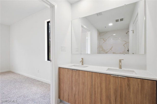 bathroom featuring visible vents, a marble finish shower, baseboards, and a sink