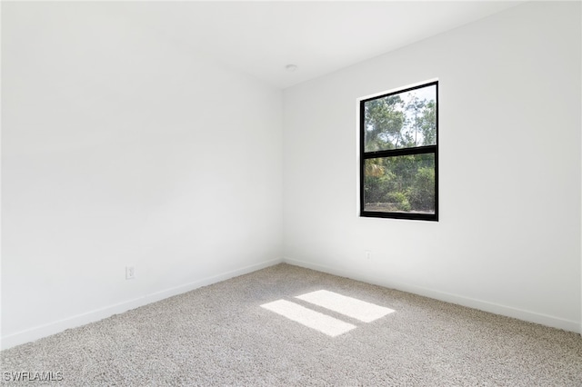 carpeted spare room with baseboards
