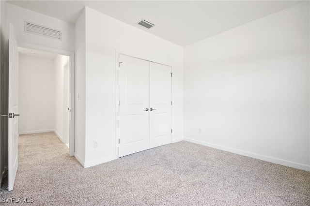 unfurnished bedroom with carpet, a closet, and visible vents