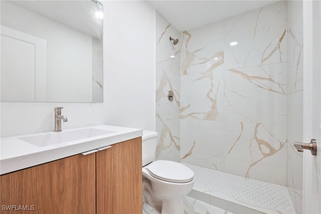 full bath with toilet, vanity, and a marble finish shower