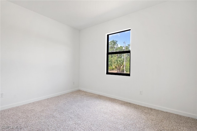 empty room featuring baseboards and carpet flooring