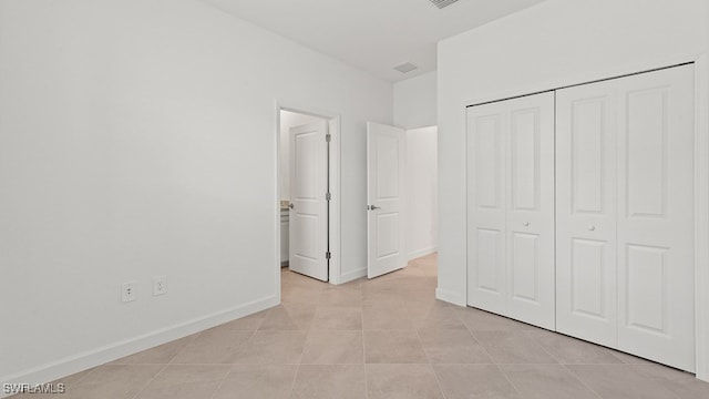 3036 Weston Manor Dr, Alva, FL 33920 - unfurnished bedroom featuring light tile patterned floors, baseboards, ensuite bathroom, and a closet
