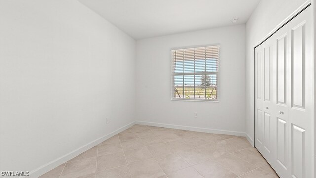 3036 Weston Manor Dr, Alva, FL 33920 - unfurnished bedroom with baseboards, light tile patterned floors, and a closet