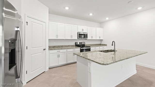 3036 Weston Manor Dr, Alva, FL 33920 - kitchen featuring white cabinets, stainless steel appliances, a sink, and a kitchen island with sink