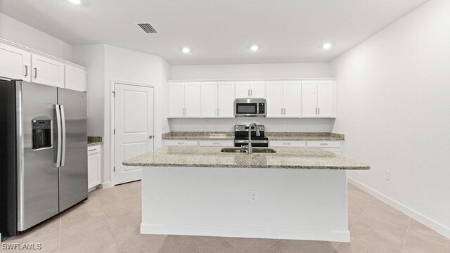 3036 Weston Manor Dr, Alva, FL 33920 - kitchen with visible vents, appliances with stainless steel finishes, a center island with sink, a sink, and white cabinets