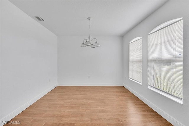 unfurnished dining area featuring a chandelier, baseboards, and light wood-style floors