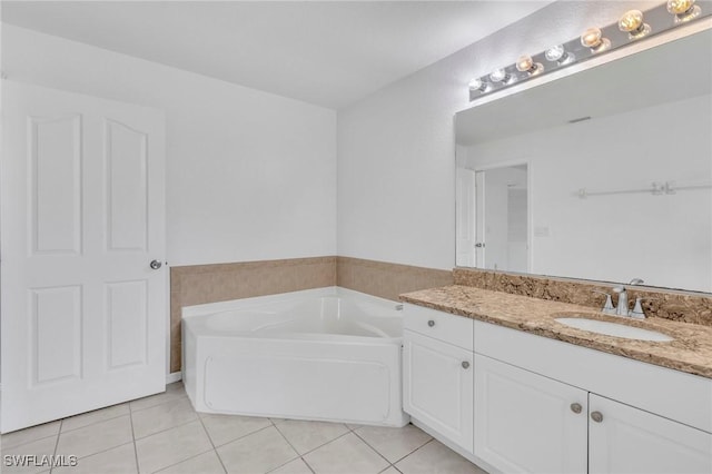 full bath featuring tile patterned flooring, a garden tub, and vanity