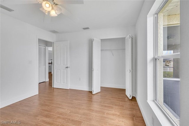 unfurnished bedroom featuring light wood-style flooring, baseboards, a closet, and a ceiling fan